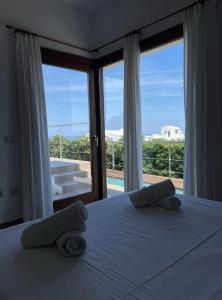 a bedroom with a bed and a large window at Villa d'Es Bot in Cala Morell