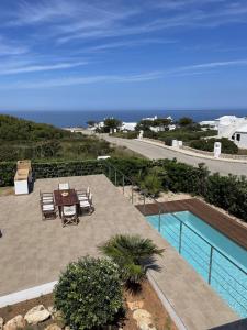 un patio con tavolo e sedie e l'oceano di Villa d'Es Bot a Cala Morell