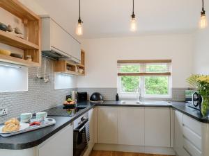 a kitchen with white cabinets and a plate of food on the counter at 1 bed property in Ilfracombe 56262 in Ilfracombe