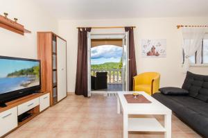 salon z kanapą i telewizorem w obiekcie Apartments Villa Amfora w Rovinj