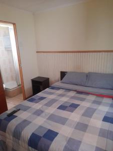 a blue and white bed in a room with a window at hostal consulado in Caldera