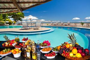 un buffet de fruta y bebidas junto a la piscina en Hotel Karapitangui, en Morro de São Paulo