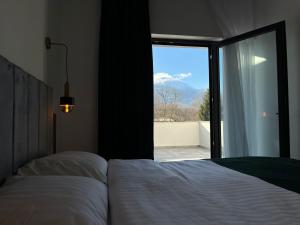 a bedroom with a bed and a window with a view at Pensiunea Cascada in Borşa