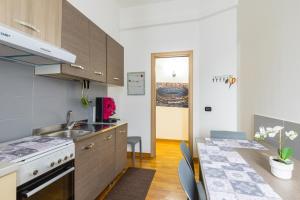 a kitchen with a sink and a stove and a table at Punto Felice Stadio in Naples