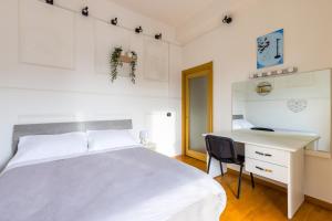 a bedroom with a white bed and a desk at Punto Felice Stadio in Naples