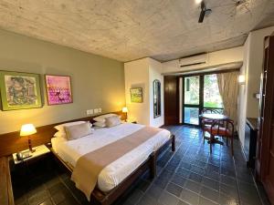サルバドールにあるホテル カタリナ パラグアスのベッドルーム(大型ベッド1台、テーブル付)