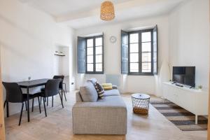 ein Wohnzimmer mit einem Sofa und einem Tisch in der Unterkunft Le Duplex - Hypercentre - Wifi in Carpentras