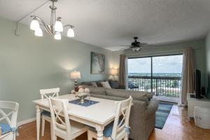 a living room with a table and a couch at Beach views with top complex amenities and covered parking! in Ormond Beach