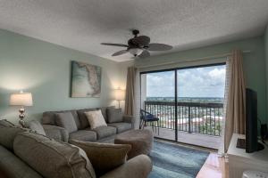 a living room with a couch and a large window at Beach views with top complex amenities and covered parking! in Ormond Beach