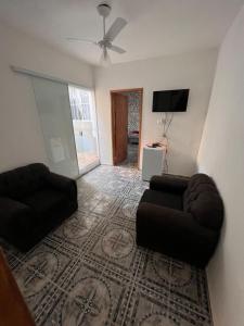 a living room with two couches and a flat screen tv at Cantinho da Irene III in Aparecida