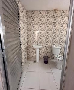 a bathroom with a toilet and a sink at Cantinho da Irene III in Aparecida