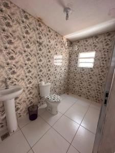 a bathroom with a toilet and a sink at Cantinho da Irene III in Aparecida