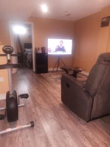 a living room with a couch and a television at One bedroom basement suite with private living room and laundry. in Brampton