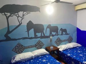 1 dormitorio con un mural de elefantes en la pared en Hotel Lu'um, en Tecolutla