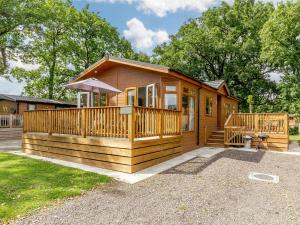 eine Holzhütte mit einer Veranda und einer Terrasse in der Unterkunft 2 bed property in Okehampton 86870 in Okehampton