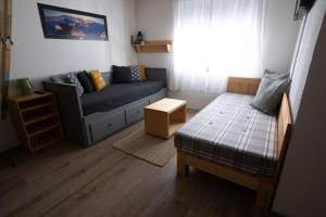 mały salon z kanapą i łóżkiem w obiekcie Alpine Retreat Čupino Sokače w mieście Kopaonik