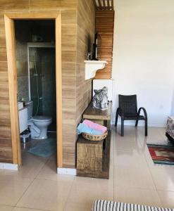 a bathroom with a toilet and a table with a basket at Hospedaria lugar de paz in Balneário Camboriú