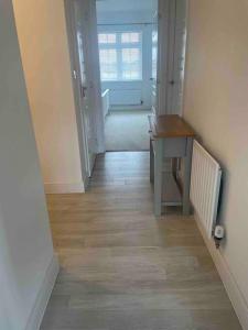 a hallway with a table and a desk in a room at Beautiful Modern Tranquil Two Bedroom Apartment in Swanscombe