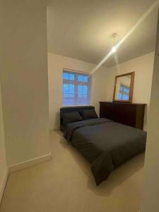 een slaapkamer met een bed, een spiegel en een raam bij Beautiful Modern Tranquil Two Bedroom Apartment in Swanscombe