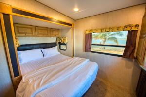 1 dormitorio con cama y ventana en una cabaña en منتجع شاطئ الورد, en Yanbu