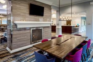 une salle de conférence avec une cheminée, une table et des chaises en bois dans l'établissement Hilton Garden Inn Tri-Cities/Kennewick, à Kennewick