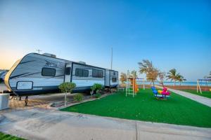 a trailer parked in a park with a playground at منتجع شاطئ الورد in Yanbu +19 photos