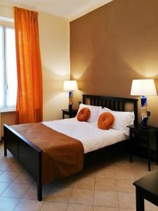 - une chambre dotée d'un lit avec deux oreillers orange dans l'établissement B&B Genova Centro, à Gênes