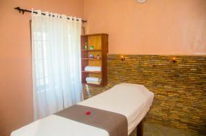 ein Schlafzimmer mit einem Bett und einer Ziegelwand in der Unterkunft Résidence Roma in Cotonou