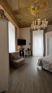 1 dormitorio con cama, sofá y lámpara de araña en Hotel Genova Liberty, en Génova