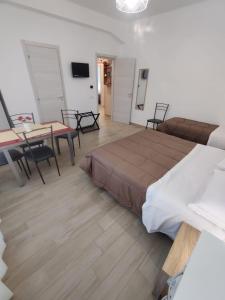 a bedroom with a bed and a table and chairs at B&B Vento Aureo Rooms in Milazzo