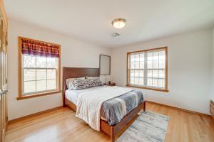 a bedroom with a bed and two windows at Family Home in Vinita with Fire Pit and Game Room! in Vinita