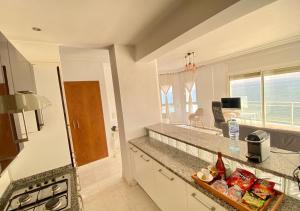 a kitchen with a counter with a view of the ocean at Vue Mer Époustouflante in La Goulette
