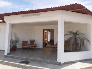 Casa blanca con sillas y patio en Villa CERRILLOS, en Camaná