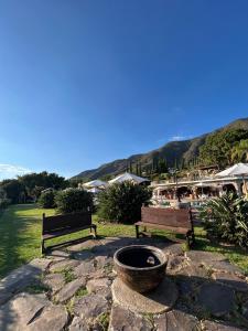 two benches and a fire pit in a park at Mama Chuy Hotel & Villas in San Juan Cosalá