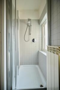 y baño blanco con ducha y bañera. en Casa Marianna - Città Alta - Appartamento Affrescato - Bergamo, en Bérgamo