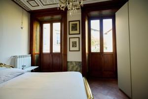 1 dormitorio con cama y lámpara de araña en Casa Marianna - Città Alta - Appartamento Affrescato - Bergamo, en Bérgamo