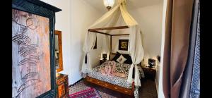 - une chambre avec un lit à baldaquin dans l'établissement Dar Najat, à Marrakech