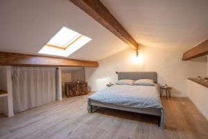 ein Schlafzimmer mit einem Bett und einem Dachfenster in der Unterkunft Le Duplex - Hypercentre - Wifi in Carpentras