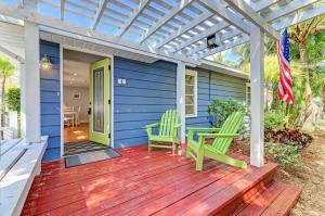 安娜玛丽亚Slo M'Ocean的蓝色的房子,配有绿色椅子和木制甲板