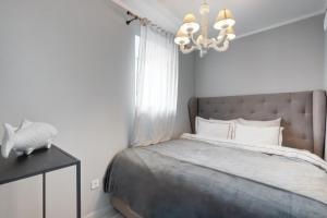 1 dormitorio con cama y lámpara de araña en Saint Andrew Boutique Apartment en Szentendre