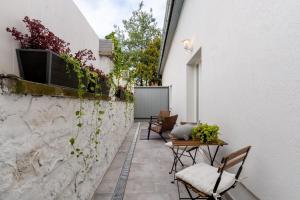 a patio with chairs and a table and a wall at Saint Andrew Boutique Apartment in Szentendre