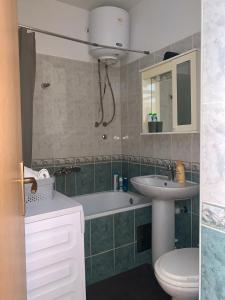 uma casa de banho com um lavatório, uma banheira e um WC. em Apartment Kvadar em Banja Luka
