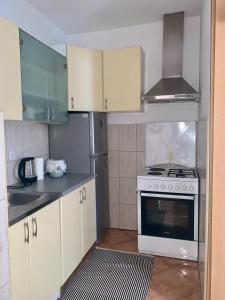 uma cozinha com armários brancos e um fogão em Apartment Kvadar em Banja Luka