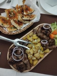 un piatto di alimenti con carne e verdure su un tavolo di 9 mezeta a Pirot