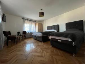 twee bedden in een kamer met een houten vloer bij 9 mezeta in Pirot