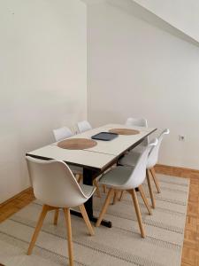 uma sala de jantar branca com uma mesa e cadeiras em Apartment Kvadar em Banja Luka