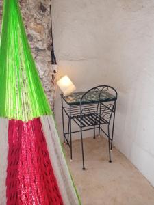 una mesa en una habitación con una lámpara y una mesa con una silla en Casa Maya Tolok - Alberca - Wifi-Starlink - Tour Sustentabilidad, en Izamal