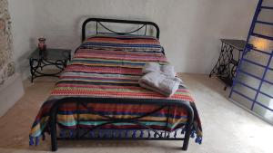 Una cama con una manta de colores encima. en Casa Maya Tolok - Alberca - Wifi-Starlink - Tour Sustentabilidad, en Izamal