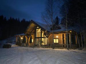 una cabaña de madera en la nieve por la noche en Mi Chalet, en Vatra Dornei