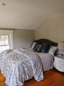 um quarto com uma cama com almofadas e uma janela em Magnolia LLC short term rentals private room on the second floor em Fergus Falls